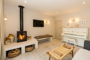 a living room with a fireplace and a piano at NEW 3 bed house with log burner and garden 5min drive to beach - Halcyon Sands in Poole