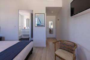 1 dormitorio con 1 cama, 1 silla y TV en Les Séraphines - Chambres d'hôtes - Guests house en Burdeos