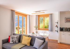 a living room with a couch and a table at Panoramapark Soleil B Garden Apartment in Wengen