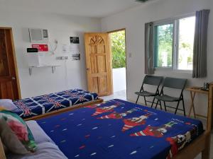 a bedroom with a bed and two chairs in it at Kathleens Vacation Place in Moalboal