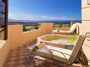 a patio with a jacuzzi tub on a balcony at Royal Garden Villas, Luxury Hotel in Adeje