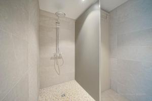 a shower with a glass door in a bathroom at Gîte familial ferme des aujes falaen in Onhaye +30 photos