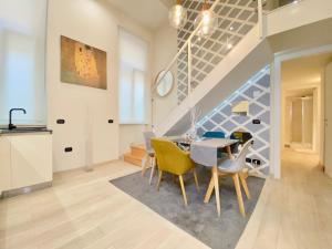 a dining room with a table and yellow chairs at Future Apartments in Milan