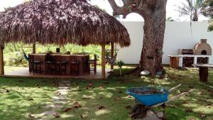 een tafel en een strohut naast een boom bij Studio Residencial Almendra in Cabarete