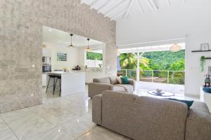 サント・リュスにあるVilla Zen & Calm - Magnifique Villa avec piscineのリビングルーム(ソファ2台付)、キッチンが備わります。