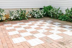 a brick patio with white flowers in front of a house at The Babcock House in Appomattox