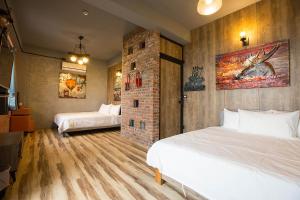 a bedroom with two beds and a brick wall at Yi Suo Yen Yu Homestay in Chenggong