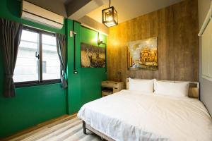 成功鎮にあるYi Suo Yen Yu Homestayの緑の壁、ベッド付きのベッドルーム1室