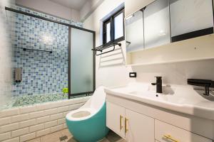 a bathroom with a toilet and a sink and a shower at Yi Suo Yen Yu Homestay in Chenggong