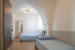 Zimmer mit 2 Betten und einem Spiegel in der Unterkunft B&B Casa Maddalena in Campi Salentina