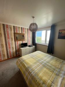 a bedroom with a bed and a window at Self Catering Spacious 2 Bed Apartment with sea views in South Erradale