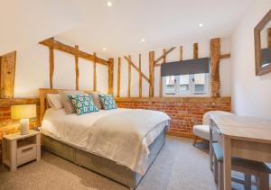 a bedroom with a bed and a table and a desk at The Corn Barn in Kersey