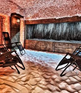 2 sillas sentadas en una habitación con nieve en el suelo en Dworek za Lasem, en Warta