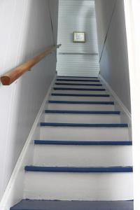 a staircase in a building with blue and white stairs at Sweet Mary home in Jamestown