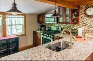 a kitchen with a sink and a stove at The Nook Lodge - cabin with hot tub at Shawnee and Camelback Mtn in East Stroudsburg