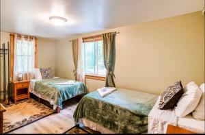a bedroom with two beds and a couch and a window at The Nook Lodge - cabin with hot tub at Shawnee and Camelback Mtn in East Stroudsburg