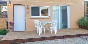 una mesa y sillas en una terraza de madera en Moonlight Suite Arad צימר אור הירח, ערד en Arad