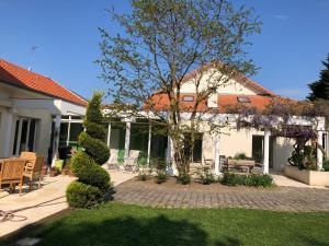 a white house with a tree in the yard at Le Jardin de Fresnes in Fresnes-en-Woëvre