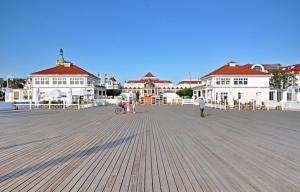 a group of people walking on a pier with buildings at Dom & House - Apartment Golden Loft Sopot in Sopot
