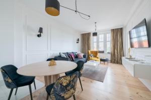 a living room with a table and a couch at Dom & House - Apartment Golden Loft Sopot in Sopot