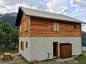 un gran edificio de madera con puerta y mesa en Chalet 6 personnes Gentiane en Les Orres