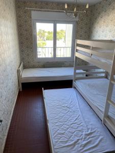Ce dortoir comprend 2 lits superposés et une fenêtre. dans l'établissement ST JEAN DE MONTS - VUE MER - 2 Chambres, à Saint-Jean-de-Monts