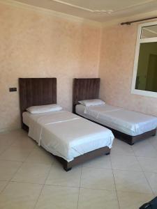 two beds sitting in a room with at Marchica Apartment Nador Jadid Wifi Klima in Nador