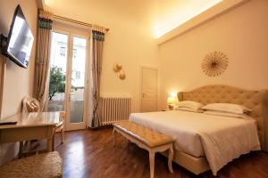 - une chambre avec un grand lit et un bureau dans l'établissement Villa Royal B&B, à Florence