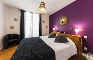 ネラックにあるLes Gîtes du château - Le loft HENRI IV - Magnifique Appartement face au châteauの紫の壁のベッドルーム1室