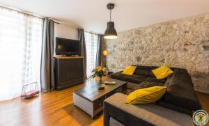 sala de estar con sofá y TV en Les Gîtes du château - Le loft HENRI IV - Magnifique Appartement face au château, en Nérac