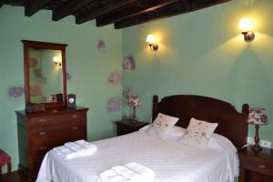 una camera da letto con un letto con lenzuola bianche e uno specchio di Casa de Mi Abuela Maria a Frontera