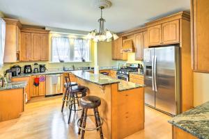 a kitchen with wooden cabinets and a stainless steel refrigerator at Charming Historic Home about 1 Mi to Dtwn Olean! in Olean