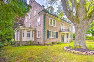 a large brick house with a tree in the yard at Charming Historic Home about 1 Mi to Dtwn Olean! in Olean