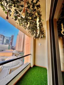 uma varanda com piso verde e uma janela com vista em York Backpackers - Jumeirah Beach no Dubai
