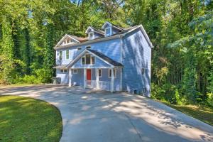 a blue house in the middle of a driveway at Stylish College Park Home with Private Garden! in Atlanta