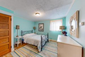 een slaapkamer met een bed en blauwe muren bij East Cove in Greenville