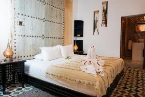 a bedroom with a bed with two towels on it at Riad Nora in Marrakesh