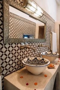 a bathroom with two sinks and a mirror at Riad Nora in Marrakesh