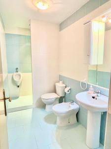 ein Badezimmer mit zwei WCs, einem Waschbecken und einem Urinal in der Unterkunft Apartamentos Ruidera in Ruidera