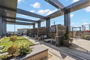 a patio on a roof with benches and plants at Placemakr Marymount Ballston in Arlington