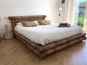 Cette chambre comprend un lit avec un cadre en bois. dans l'établissement Beautiful T3 terrasse Nice, à Nice