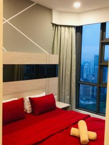 a bedroom with a red bed with a large window at The Robertson by KL MoonLight Suites Bukit Bintang in Kuala Lumpur