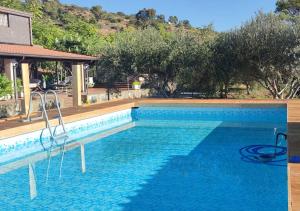 a swimming pool with blue water in front of a house at Peri Peri Etna Guest House in Montargano