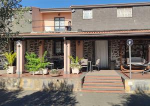 a house with potted plants on a patio at Peri Peri Etna Guest House in Montargano