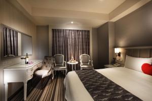 Una habitación de hotel con una cama, un escritorio y sillas. en Grace Hotel, en Taipéi 47 fotos más