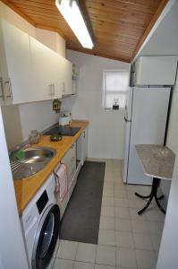 a small kitchen with a sink and a refrigerator at Casa da Praya in Horta