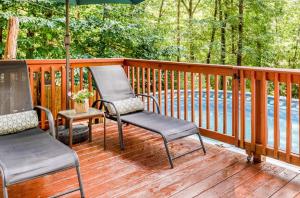 duas cadeiras e um guarda-sol num deque em Pocono cabin with private pool at Shawnee Mtn em East Stroudsburg