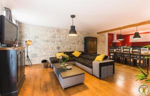 a living room with a couch and a tv at Les Gîtes du château - 2 Magnifiques Appartements face au château Henri IV in Nérac