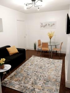 a living room with a black couch and a table at CityHost Apartments - Newcastle in Elswick