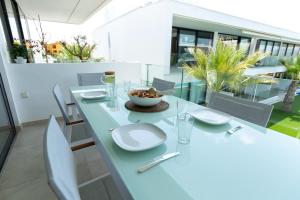 comedor con mesa blanca y sillas en Luxe nieuwbouw penthouse op 600 m van het strand!, en Los Nietos